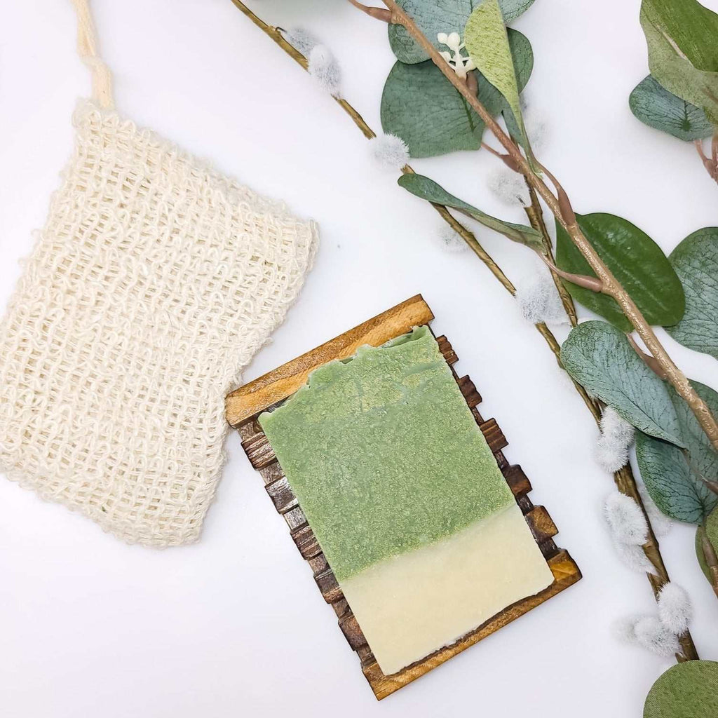 Eco-friendly soap saver bag with bar soap and natural elements.