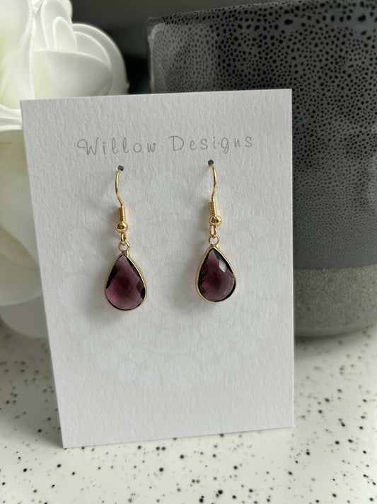 Burgundy Gemstone Dangly EarringsThese burgundy gemstone earrings are 14K gold plated. They are hypoallergenic and nickel free.Burgundy Gemstone Dangly EarringsCG Pure Wash